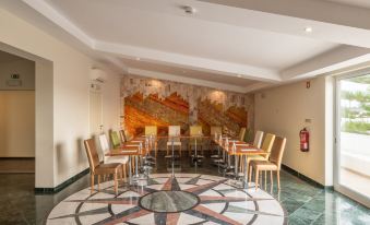 a modern meeting room with a marble floor and chairs arranged in a circular pattern at Lagoa Hotel