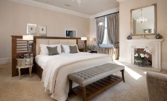 a large bedroom with a king - sized bed and a fireplace , creating a warm and inviting atmosphere at Rockliffe Hall Hotel Golf & Spa