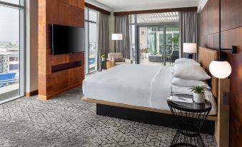 a luxurious hotel room with a king - sized bed , a flat - screen tv , and a sliding glass door leading to a balcony at Sheraton Puerto Rico Resort & Casino