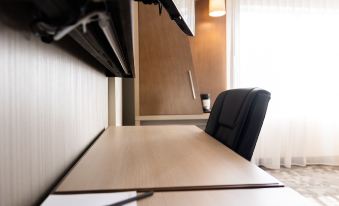 a black chair is placed in front of a wooden desk with a computer monitor at Courtyard Rome Riverwalk