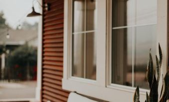 a porch with a wooden swing hanging from a tree , surrounded by a brick wall at Wine Stone Inn