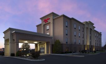 a hilton garden inn hotel with its name prominently displayed on the building , and the entrance to the hotel at sunset at Hampton Inn Lenoir City