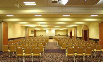 a large conference room with rows of chairs arranged in a semicircle , ready for a meeting or event at Hotel Kompas