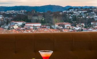 a table with two glasses of drinks and a cocktail in front of a cityscape at Hotel Fundador