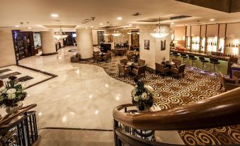 a luxurious hotel lobby with marble floors , wooden furniture , and elegant decorations , including a staircase leading to the upper floor at Super Hotel Candle