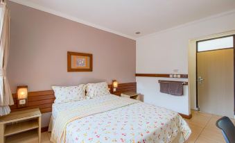 a bedroom with a large bed , wooden headboard , and a painting on the wall , along with a sink and mirror at Applewood B&B