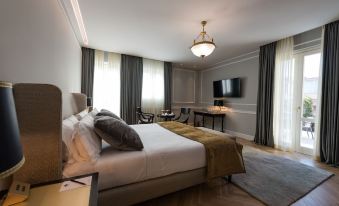 a large bed with white sheets and a wooden headboard is in the middle of a room at Grand Hotel Et des Palmes