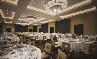 a large , well - lit banquet hall with multiple round tables and chairs set up for a formal event at DoubleTree by Hilton Reading