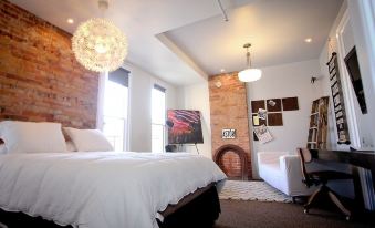 a cozy bedroom with a white bed , brick walls , and a large bed in the center at Hart House Hotel