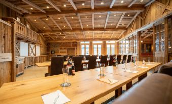 a large conference room with wooden walls , a long table set for meetings , and multiple chairs arranged around it at Hotel Adler - Paulas Alb