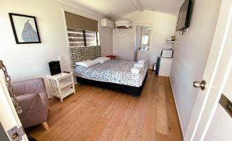 a spacious bedroom with a large bed , a tv , and a bathroom next to it at Warrego Hotel Motel Cunnamulla