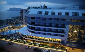 a large , modern hotel building situated on the side of a street with cars parked nearby at Sunprime C-Lounge