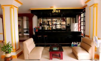 a bar with a large window , red and black colors , and tan chairs in front of it at Cay Thong Hotel