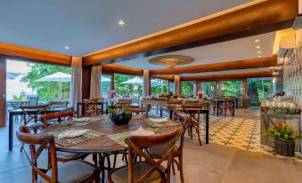 a large dining room with wooden tables and chairs arranged for a group of people to enjoy a meal together at Wyndham Ilhabela Casa di Sirena