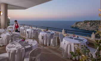 an outdoor dining area with tables and chairs set up for a large group of people at Athina Palace Resort & Spa