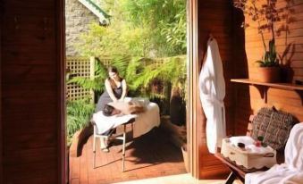 a woman is receiving a massage in a room with a view of the outdoors at Mary Cards Coach House