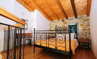 a cozy bedroom with a wooden ceiling , a black metal bed frame , and a white comforter on the bed at Villa Victoria