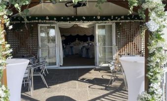 an outdoor wedding venue with white chairs , tables , and flowers , set up for a celebration at Rettendon Lodge