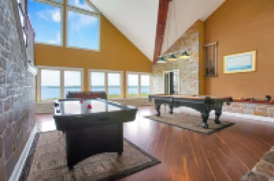 Stunning waterfront villa with indoor pool and kids swing set and play area.