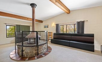a cozy living room with a fireplace , couch , and couches , as well as a fireplace in the background at Discovery Parks - Jindabyne