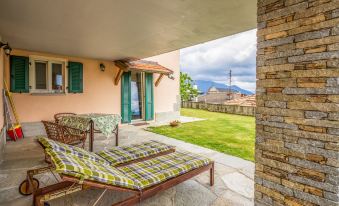 a patio with two lounge chairs and a table , overlooking a grassy area and mountains at Federica