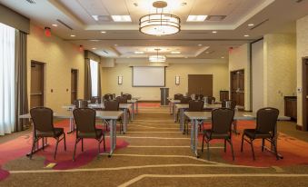 a large , empty conference room with multiple rows of chairs and tables set up for a meeting or event at Hilton Garden Inn Uniontown