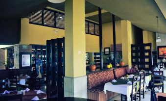 a modern , well - lit restaurant with yellow walls and black ceiling , featuring a dining area with tables and chairs at Hotel San Carlos Tequisquiapan