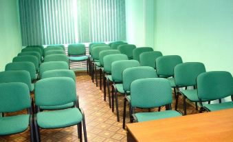 a conference room with rows of green chairs arranged in a semicircle , and a desk in the center at Norilsk
