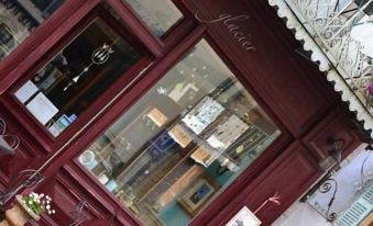 a storefront with a large window showcasing a variety of items for sale , including jewelry and watches at Le Petit Chou