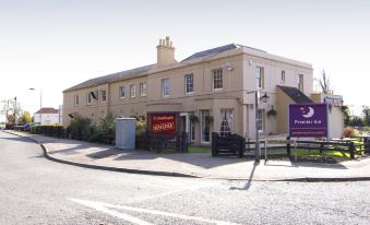 "a large building with a sign that says "" coaching rd "" and a clock on the side" at Arundel