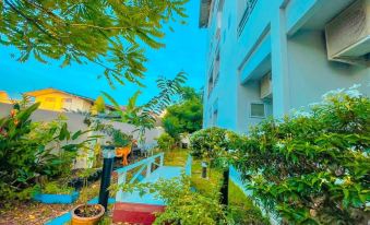 a beautiful courtyard with lush greenery and blue walls , creating a serene and inviting atmosphere at The Linux Garden Hotel