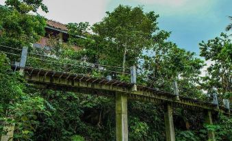 a wooden bridge spanning a body of water , surrounded by lush greenery and trees on both sides at Recidencia Del Hamor