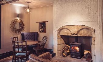 a cozy living room with a fireplace , chairs , and a mirror on the wall , creating a warm and inviting atmosphere at The New Inn - Yealand