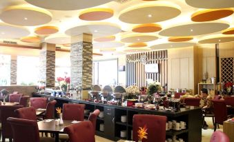 a modern restaurant with a dining area featuring a variety of dishes and utensils on the table at Sapphire Sky Hotel & Conference