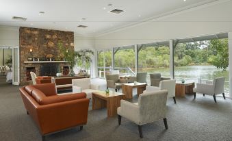 a spacious , well - lit living room with multiple couches and chairs arranged around a dining table at Cape Lodge