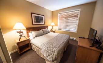 a large bed with a white comforter and two nightstands , one on each side of the bed at Sundance Resort