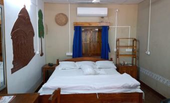 The bedroom has two beds and an open doorway that leads to the other side at Hotel Banalata