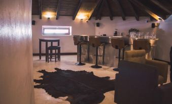 a modern bar area with a cowhide rug on the floor , wooden chairs , and a few bottles at Casa San Miguel Hotel Boutique y Spa