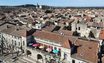 a bird 's eye view of a city with red - tiled roofs and buildings , with people walking on the street at Hotel des Artistes