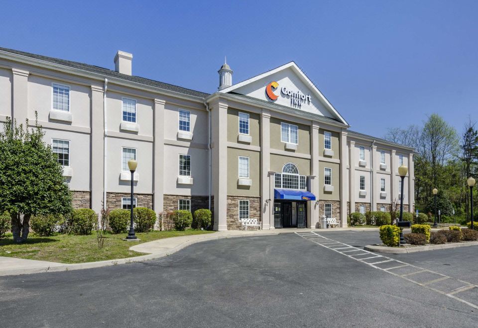 a large building with a logo on the front , possibly a hotel or an office building at Comfort Inn
