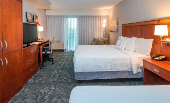 a hotel room with a large bed , desk , and window , along with other amenities such as a desk and chair at Courtyard by Marriott Montgomery Prattville