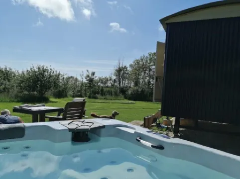 Romantic Apple Tree Shepherd's Hut with optional hot tub and shared EV charger.