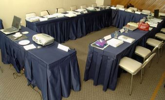 a conference room set up for a meeting , with multiple tables and chairs arranged in a semicircle at El Paseo