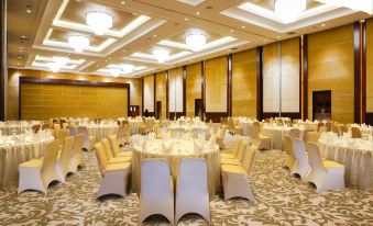 a large , empty banquet hall with numerous round tables and chairs set up for a formal event at Swiss-Belhotel Serpong