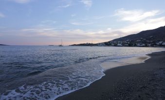 A picturesque sunset view from the beach, with mountains in the background and a clear blue sky on the far side at Brazzera Hotel