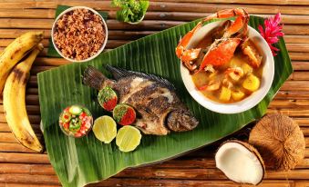 a dining table with a variety of food items , including fish , crab , rice , and vegetables at Villa Caribe