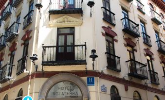 "a white building with balconies and a blue sign that says "" hotel palazzo "" is shown" at Hotel Inglaterra