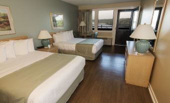 a hotel room with two beds , a window offering a view of the ocean , and wooden flooring at Dale Hollow Lake State Resort Park