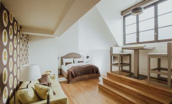 a cozy bedroom with hardwood floors , a bed , and a staircase leading to a loft area at Burg Reichenstein