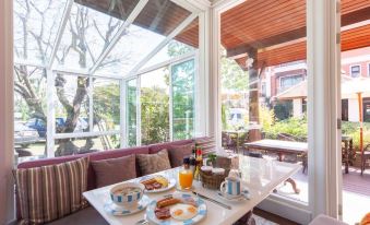 a dining table set with breakfast items , including eggs and coffee , in front of a window at Content Villa Chiangmai